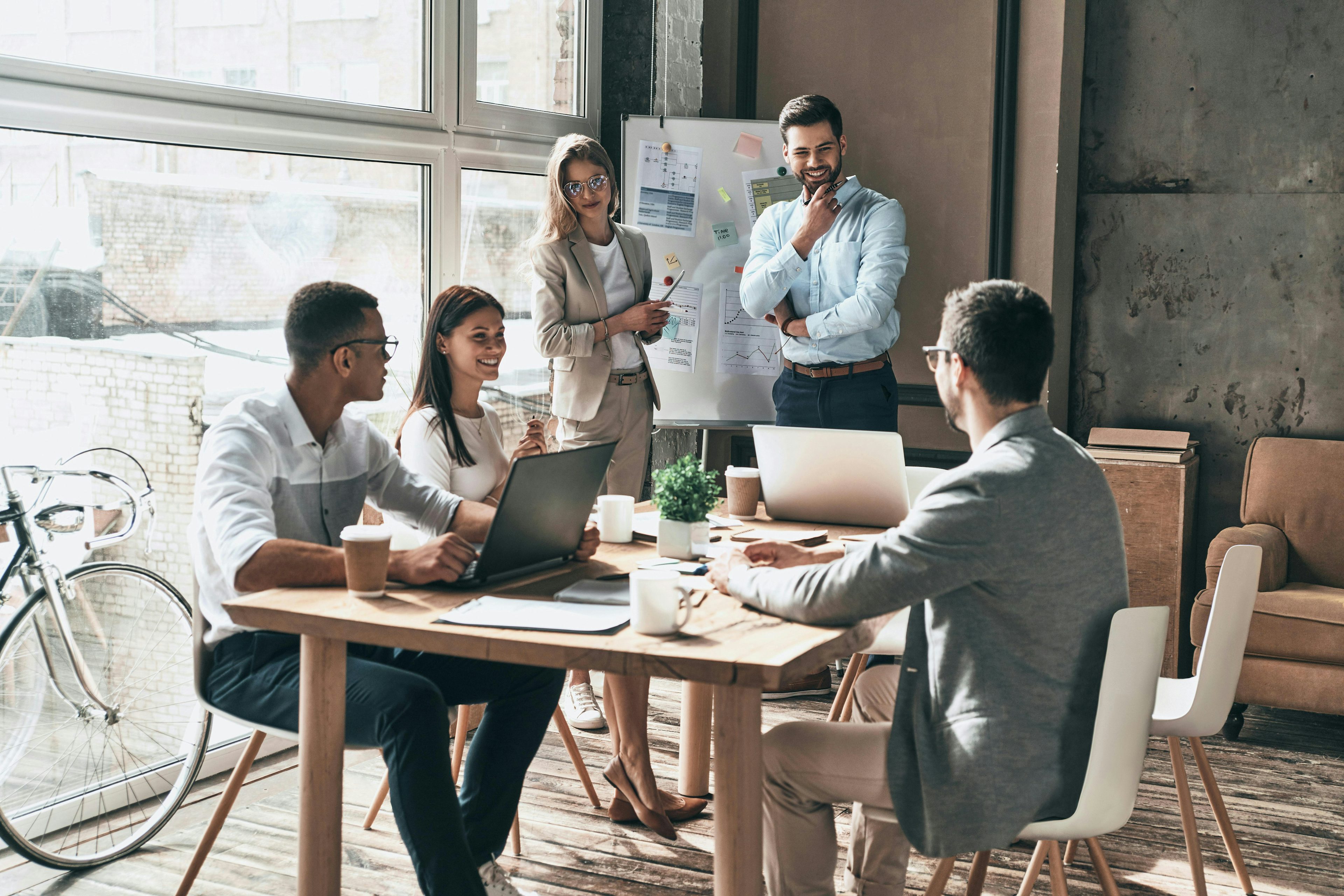 A team of people in an office talking over a whiteboard