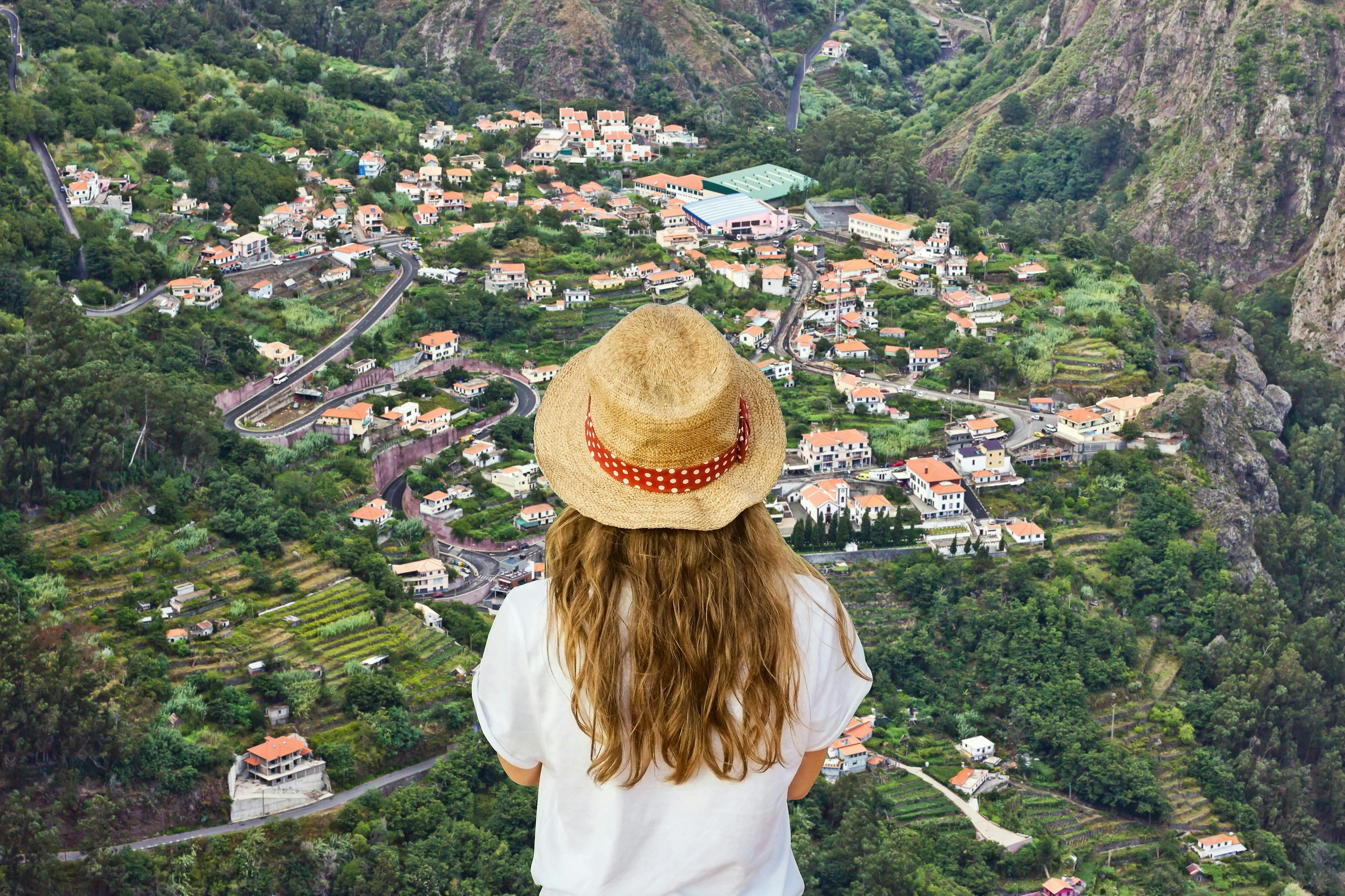 Uma pessoa olhando para um vale do topo de uma montanha na Madeira, Portugal.